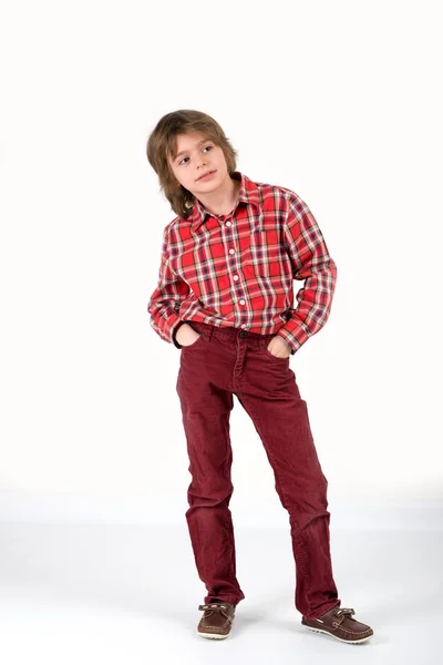 O rapaz com uma camisa vermelha em uma seção e em velveteen jeans estão — Fotografia de Stock