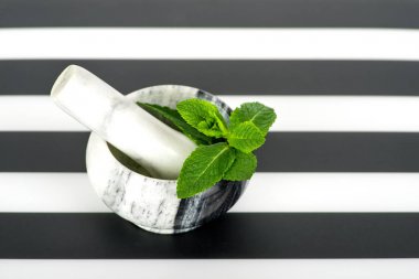 bir plastik s üzerinde mermer bir harç dal taze nane yatıyor