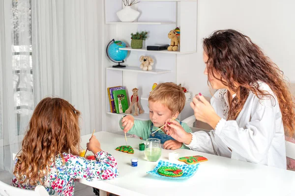 Niños pequeños con una niñera para prepararse para la Navidad. Ellos si — Foto de Stock