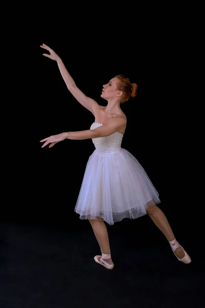 A bailarina em pointes e um vestido dança em um backgroun preto — Fotografia de Stock