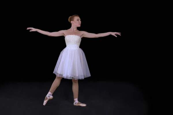 A bailarina em pointes e um vestido dança em um backgroun preto — Fotografia de Stock