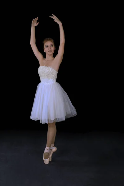 A bailarina em pointes e um vestido dança em um backgroun preto — Fotografia de Stock