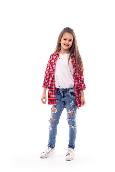 Studio bild av en ung leende flicka bär jeans och en röd che — Stockfoto