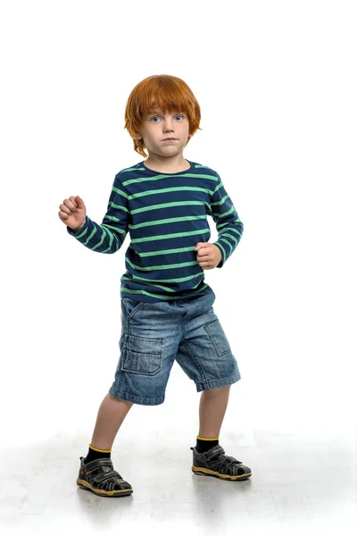Постріл серйозного маленького рудого хлопчика танцює, ізольований — стокове фото
