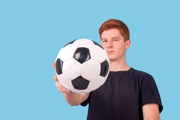 Aufnahme eines rothaarigen Teenagers, der einen Fußball in der Hand hält — Stockfoto