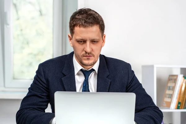 Foto van een jonge serieuze man aan het werk op laptop. — Stockfoto