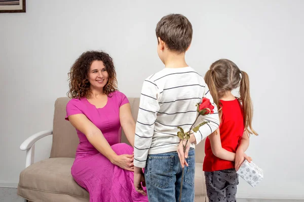 Постріл матері та її двох дітей, що тримають подарунок та квітку фо — стокове фото