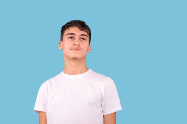 Beyaz gömlek giyen esmer bir gencin stüdyo fotoğrafı.