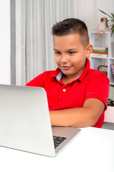 Школьник, использующий ноутбук для выполнения домашней работы — стоковое фото