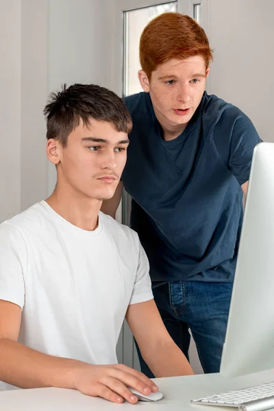 Dos chicos adolescentes serios están usando la computadora y discutiendo som —  Fotos de Stock