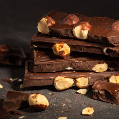 Koyu dokuma masasında duran fındıklı çikolata parçaları..