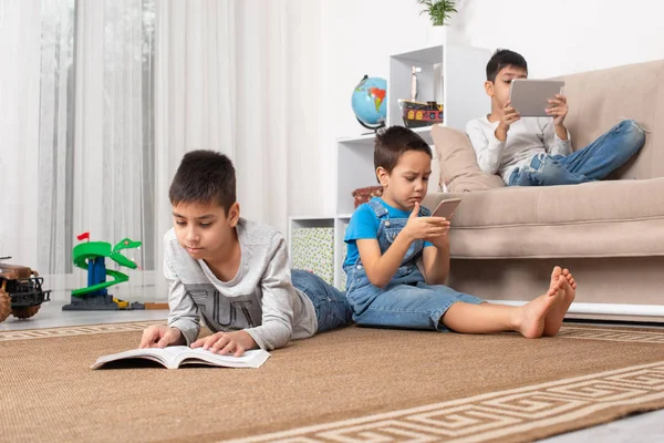 Crianças de diferentes idades usam gadgets para jogos, comunicação — Fotografia de Stock
