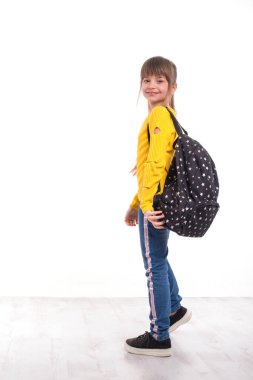 A young smiling schoolgirl  goes fun with a backpack.  