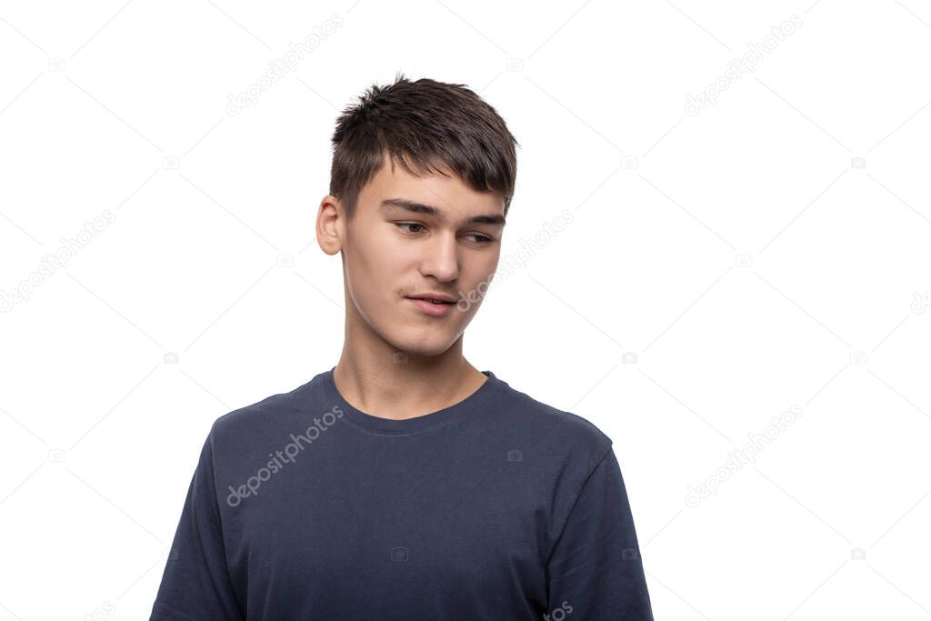 Waist up  portrait of the young boy teenager of the brunette  wearing  blue shirt on a white background  in studio. 