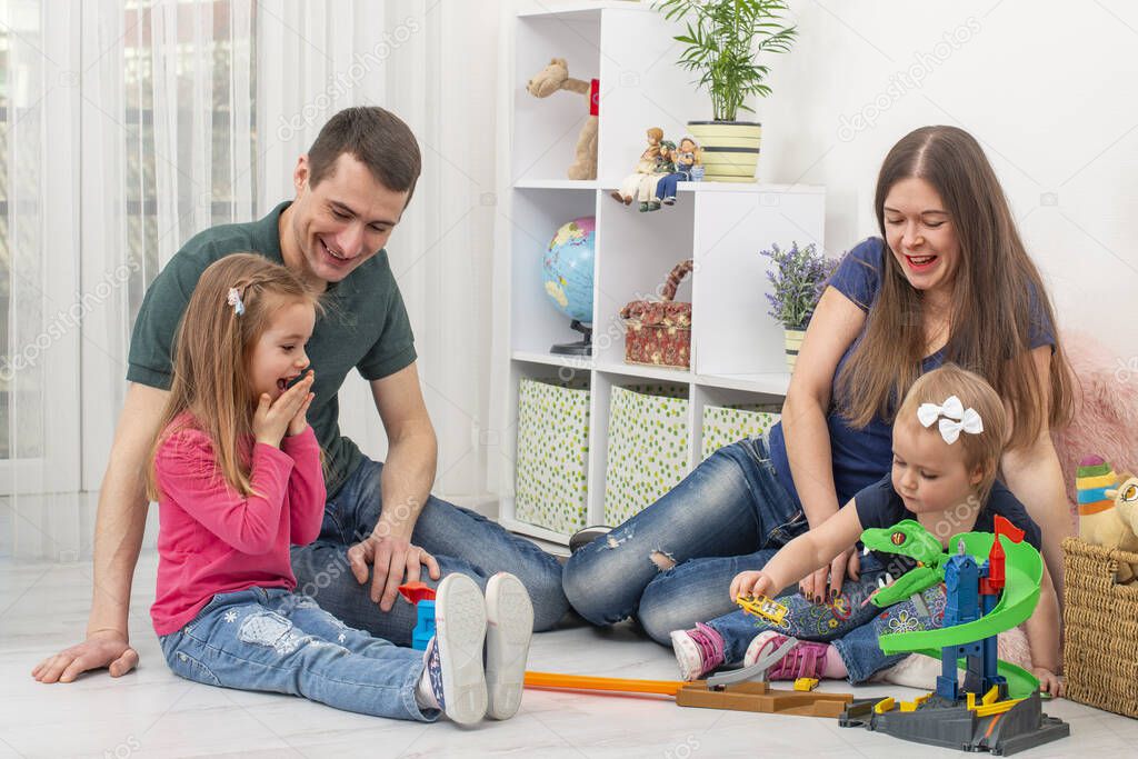 A young family with two little children spend time together at home.  The concept of family values.  Life style.  