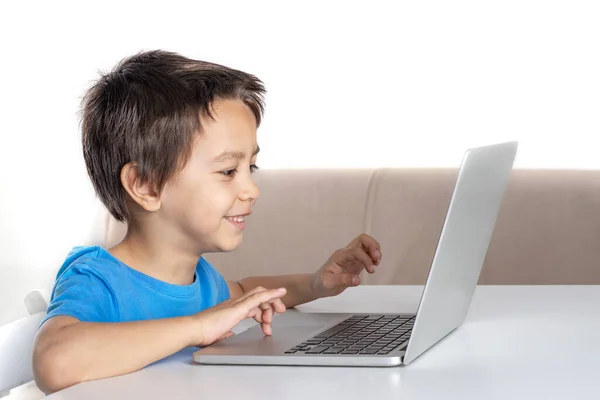 Tiro Garotinho Sorridente Sentado Uma Mesa Casa Navegando Internet Laptop — Fotografia de Stock