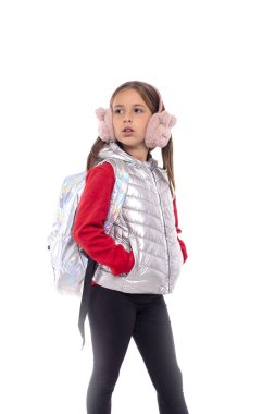 Parlak ceketli, aynı renkte sırt çantası olan, izole edilmiş, ciddi bir genç kızın yarım boy portresi.