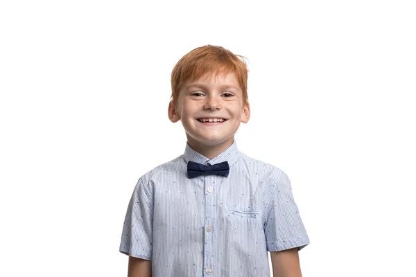 ウエストアップポートレートの笑顔Redhead若いです男の子身に着けています青シャツとともに弓で白い背景 — ストック写真