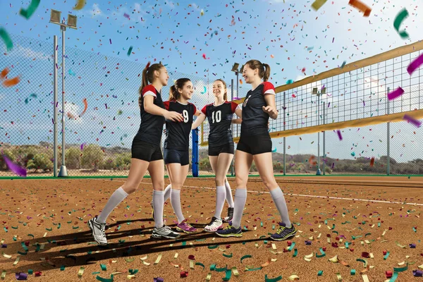 Female volleyball team celebrating victory