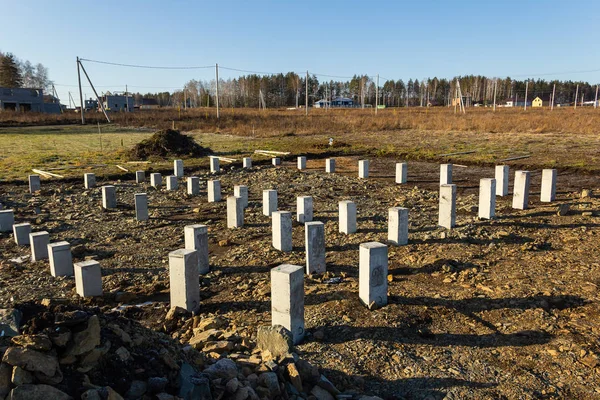 Construction de fondations en pieux de béton pour une maison dans un village de chalets. Automne, ensoleillé Image En Vente