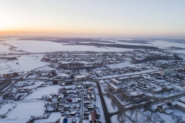 Ufukta Oktyabrski köyünün yolları ve Chelyabinsk yolu görünüyor. - Rusya. Kış, akşam, gün batımı