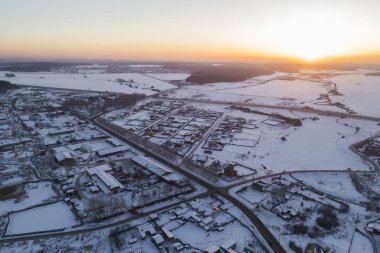Ufukta Oktyabrski köyünün yolları ve Chelyabinsk yolu görünüyor. - Rusya. Kış, akşam, gün batımı
