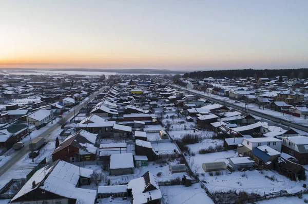Luftaufnahme des Dorfes Oktyabrski mit Straßen und Hausdächern. Russland. Winter, Abend, Sonnenuntergang — Stockfoto