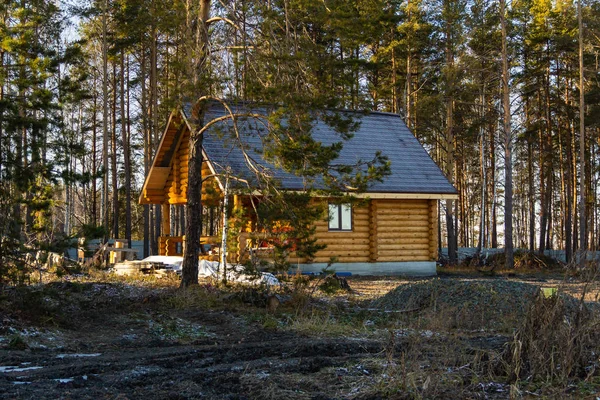 Nouvelle maison en bois rond en construction dans la forêt. Automne, jour, ensoleillé Image En Vente
