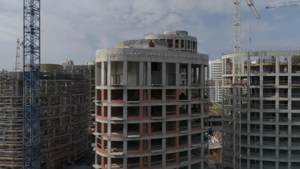 高層マンションや市内のクレーンの建設の空中ショット 都市インフラ開発 夏の晴れた日 カメラは建物から飛び去る — ストック動画