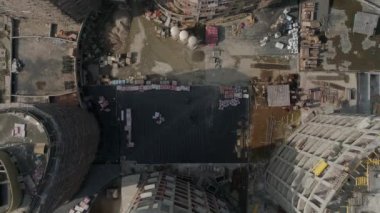 Şehirdeki yüksek binaların ve vinçlerin havadan çekilmiş görüntüleri. Kentsel altyapı geliştirme. Yaz güneşli bir gün. Kamera aşağı bakar ve yükselir.