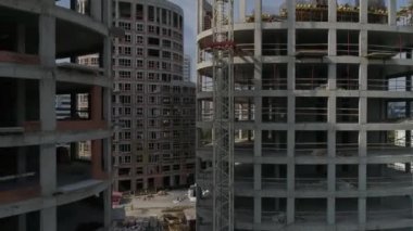 Şehirdeki yüksek binaların ve vinçlerin havadan çekilmiş görüntüleri. Kentsel altyapı geliştirme. Yaz güneşli bir gün.