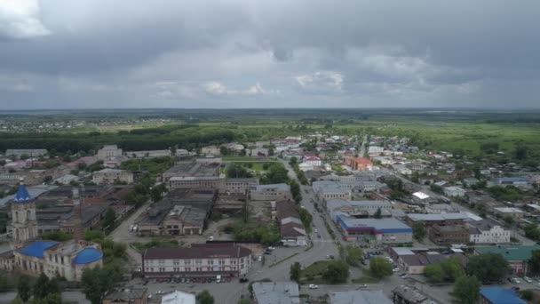 低い住宅と市内の工場近くの廃墟教会の空中ビュー 町の森の外 夏の日 ロシアのスヴェルドロフスク州アービット市 — ストック動画