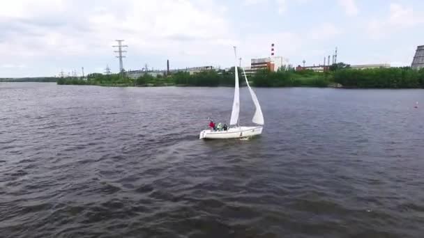 レガッタ 工業景観と都市の池でヨットをセーリングの空中ビュー ヨットの人々はカメラで手を振っている 夏曇りの日 — ストック動画