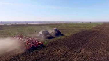 Traktör tarlasının havadan görünüşü. Yaz, güneşli bir gün. Arka plandaki ormanda..