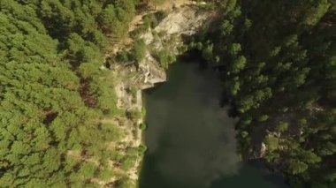 Ormanda küçük bir göl ve talk rock. Havadan. Sysert şehrinde bir konuşma taşı. Sverdlovsk bölgesi, Rusya