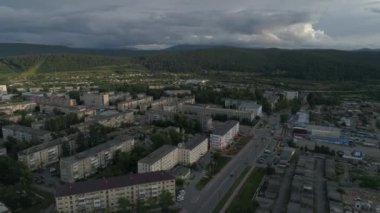 Şehir havadan görülebiliyor. Yüksek ve alçak binalar var. Arabalar sürüyor. Ural Dağları 'nın dışında. Yaz, akşam. Rusya, Chelyabinsk bölgesi, Satka şehri
