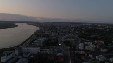 Akşam şehri Tomsk 'un günbatımındaki hava manzarası. Tom River ve Tomsk bölgesinin yönetim binası. Arabalar yollarda gider. Yaz sıcak akşamı. Rusya, Sibirya, Tomsk bölgesi