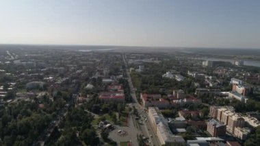 Tomsk şehrinin bir sürü ağacı ve Tom nehri olan havadan görüntüsü. Şehrin yüksek ve alçak evleri ve binaları var. Yaz güneşli bir gün. Rusya, Tomsk şehri