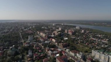 Tomsk şehrinin bir sürü ağacı ve Tom nehri olan havadan görüntüsü. Şehrin yüksek ve alçak evleri ve binaları var. Yaz güneşli bir gün. Rusya, Tomsk şehri