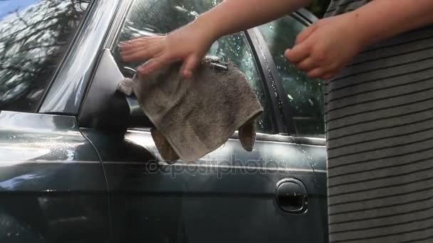 Girl washing car mirror with old rag — Stock Video