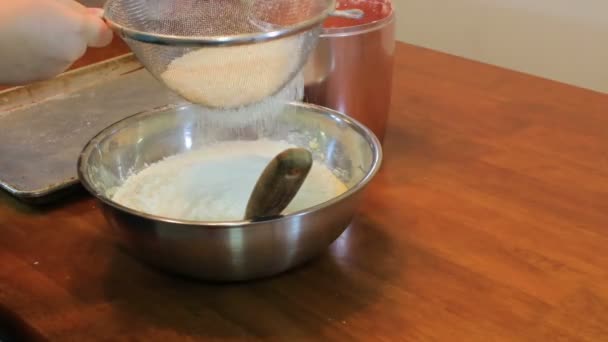 secouer la farine à travers le tamis 