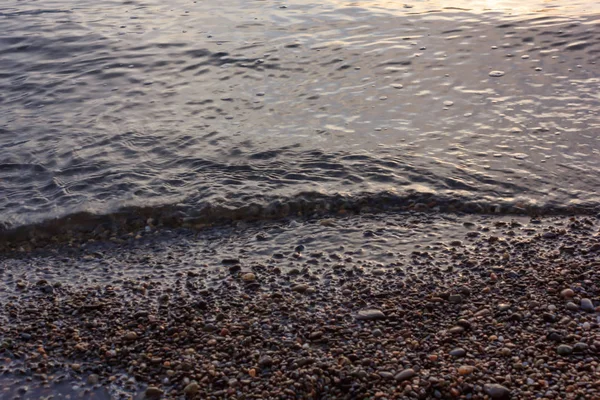 Dunkles Wasser plätschert am Strand — Stockfoto