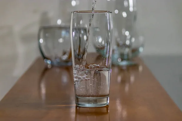 Group of glasses on wood one with water — Stock Photo, Image