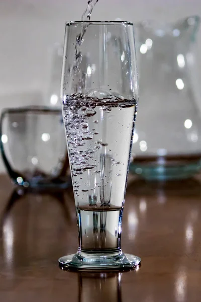 Close up water pouring into tall glass — Stock Photo, Image