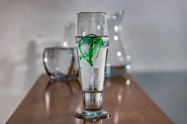 Green food coloring in water on table — Stock Photo, Image