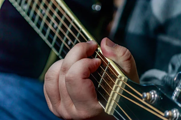 Ручная игра на черной гитаре — стоковое фото