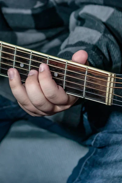 hand holding chord on guitar