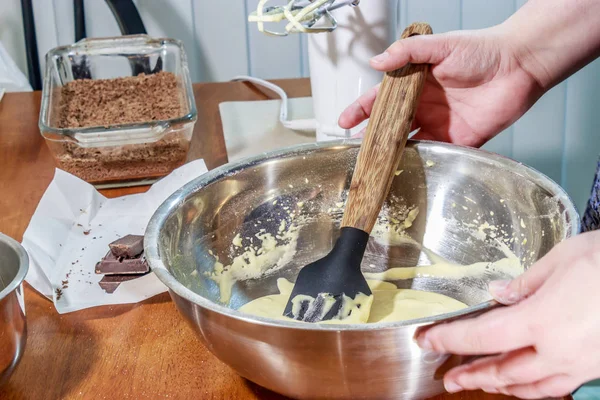Folding cake batter together with shaved chocolate in background — Stock Photo, Image