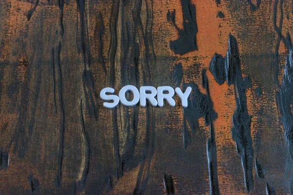Het woord sorry geschreven in witte drukletters — Stockfoto