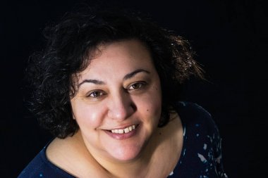 kameraya bakarken gülümseyen mutlu esmer kadın